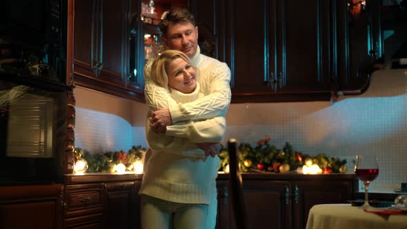 Loving Husband Singing Serenade Hugging Wife Dancing with Spouse in Kitchen at Home