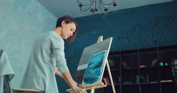 Young Woman Artist Paints a Picture of Abstraction