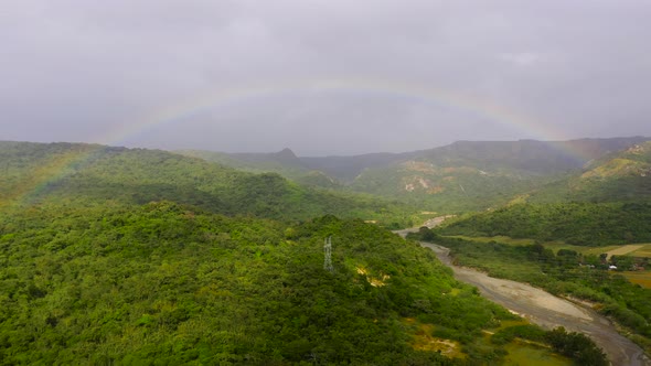 Rainbow Over the River in the Highlands. Mountains on Luzon Island, Philippines