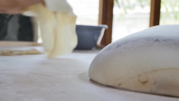 Two Female Bakers Preparing a Thin Dough for the National Pita Unrolls It with Their Hands and