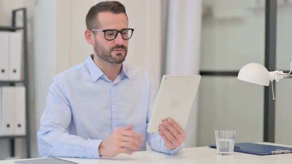 Middle Aged Man Talking on Video Chat on Tablet