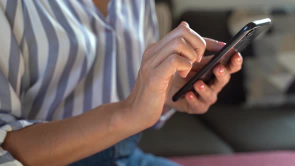 Woman's hand using smartphone and finger wiping on display