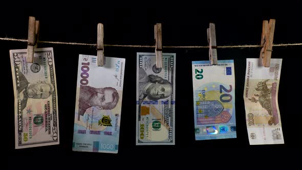Banknotes of Different Countries Dry on a Clothespin Rope