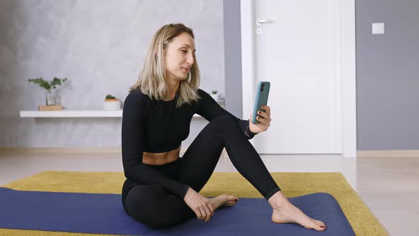 Fitness Trainer Woman doing Sport Lessons at Home using a Smartphone, Copy Space