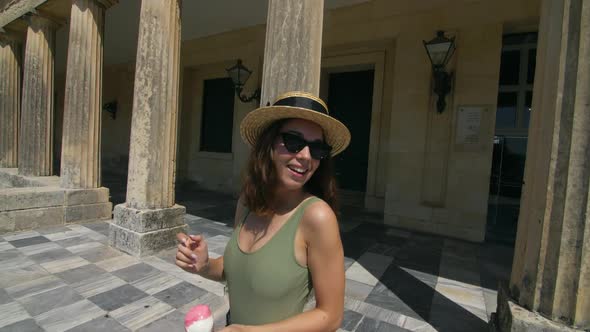 Carefree Woman Walking on Column Building Corridor at Summer Travel