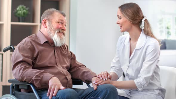 Female Doctor Nurse Talking with Disabled Grandfather Discuss Rehabilitation Therapy at Hospital