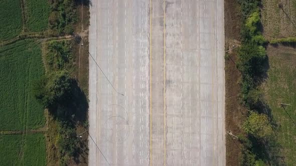 Single White Car driving along 14 Lane Highway Naypyidaw Myanmar Capital Aerial Top Shot