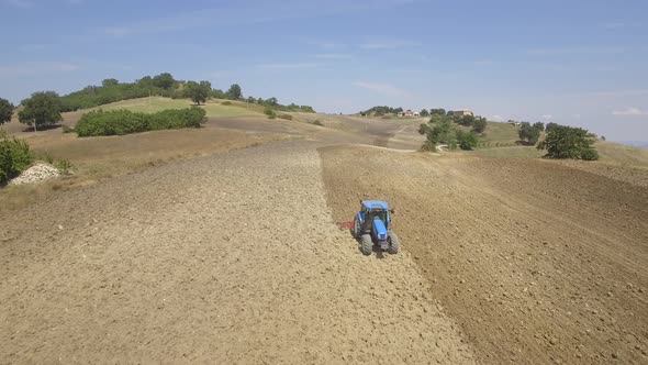 Farmer on tractor plowing a field in Umbria, Italy