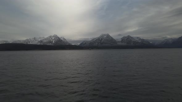 Dramatic Sky Over Tranquil Sea With A Sailing Ship And The Lyngen Alps In The Distance, Northern Nor