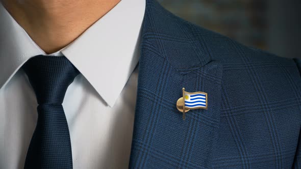 Businessman Walking Towards Camera With Country Flag Pin Uruguay