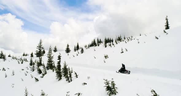Snowmobile Action Speeding Down Cattrack Trail Winter Scene Traveling Mountain Forest Aerial