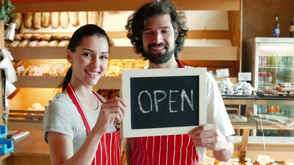 Bakers holding open signboard