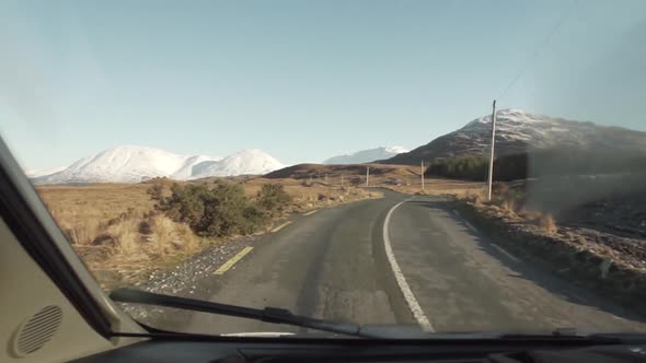 Lonely car driving through mountain location in Ireland