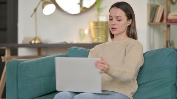 Young Woman with Laptop Coming Back Sitting on Sofa