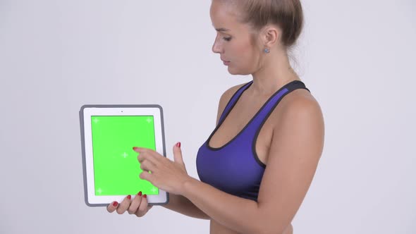 Profile View of Young Beautiful Blonde Woman Using Digital Tablet