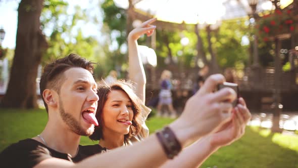 Young Beautiful Couple Smiling Making Selfie Sitting in City Park