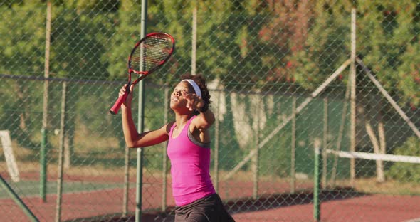 Video of focused african american female tennis player holding racket and hitting ball