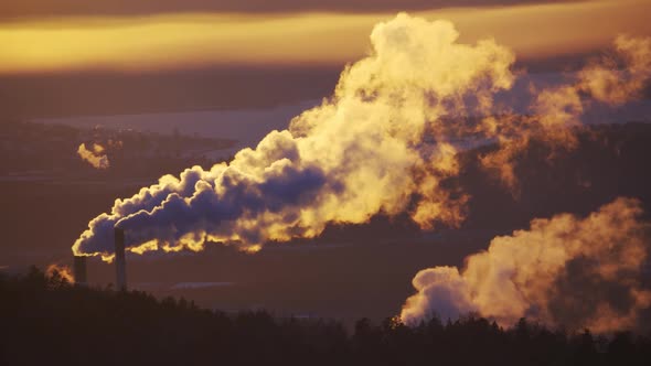 Industrial Zone with a Large Red and White Pipe Thick White Smoke is Poured From the Factory Pipe in