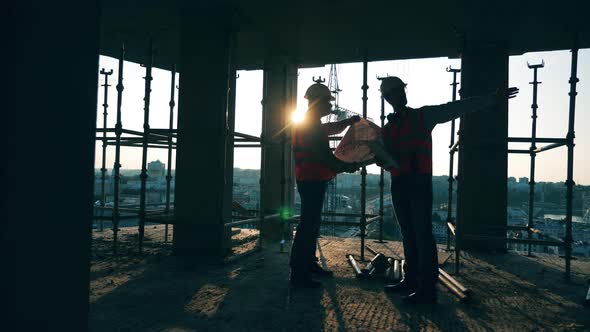 Professional Construction Engineers, Construction Architects with a Blueprint on a Construction Site