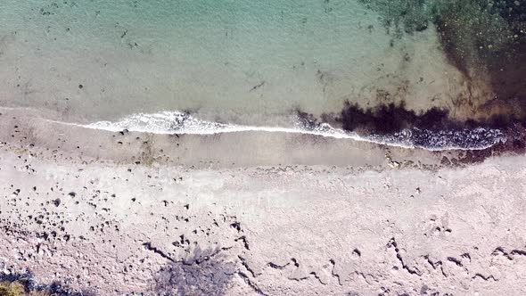 Aerial birds eye view of stunning white sand beach and waves crashing on a tropical island in Timor