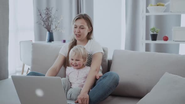 Mother Woman with a Toddler Child are Played with a Laptop