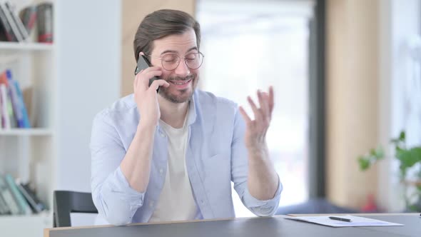 Man in Glasses Talking on Smartphone in Office