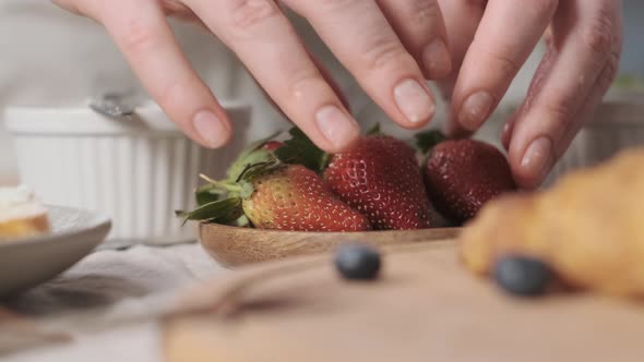 Woman Decorate Croissants with Strawberries