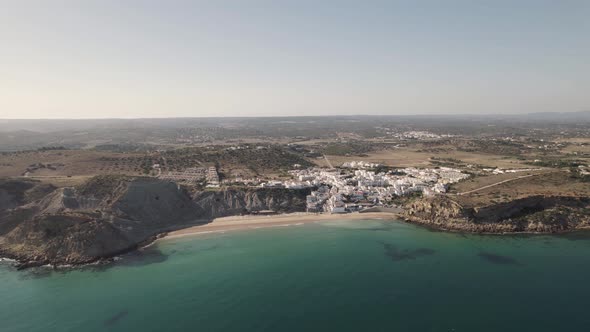 Aerial view turquoise sea and old fishing village with whitewashed cottages houses in Burgau