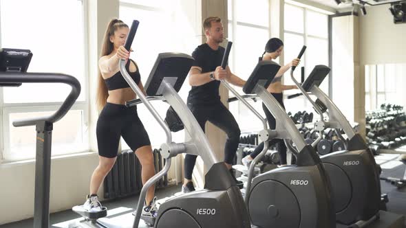 Diverse People Training on Treadmill and Elliptical