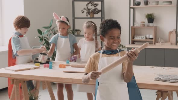 African Boy with Rolling-Pin in Kitchen