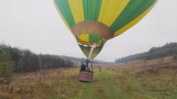 Travelers Inflate the Balloon with Warm Air and Prepare to Fly in a Balloon Above the Clouds