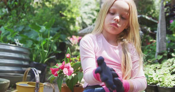Little girl putting gloves before gardening
