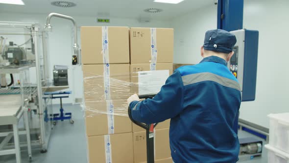 Back View of Loader Operating Manually the Fork Truck at the Pharmaceutical Plant