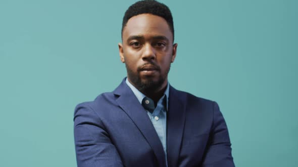 Video of smiling african american man looking at camera on blue background