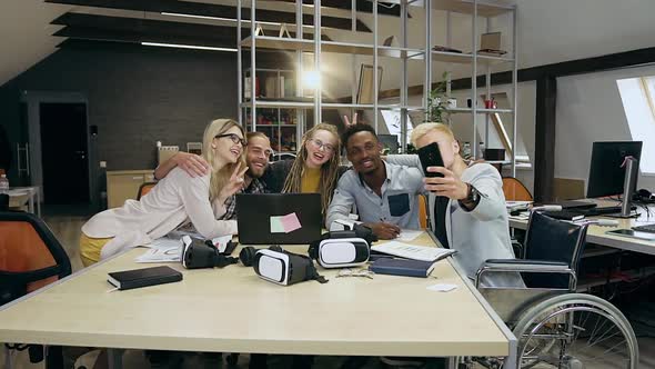 Modern Young Office People Making Selfie on Phone while Sitting at the Worktable