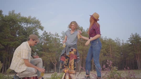 Group of Young Friends Making Picnic with Guitar and Cold Beer or Limonade Chilling and Having Fun