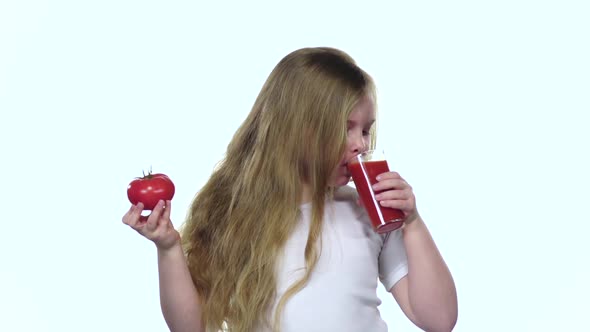 Little Girl Drinks Tomato Juice and Licks Her Lips. White Background. Slow Motion