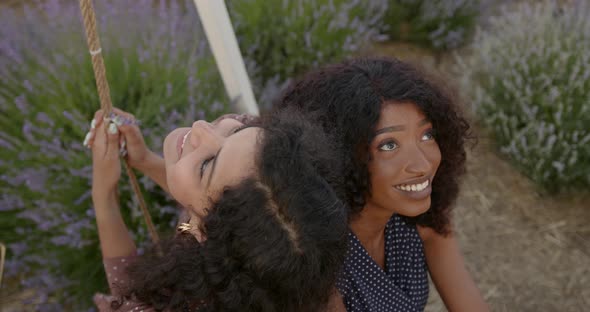 Female Diverse Friends on a Swing in Lavender Field