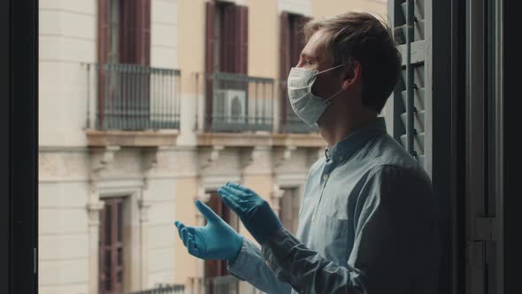 Young Man in a Mask and a Blue and White Shirt Applauding Doctors on the Balcony at 8 in the