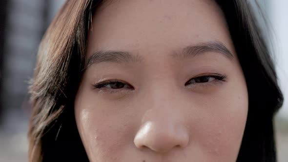 Closeup of Asian woman looking at camera outdoor