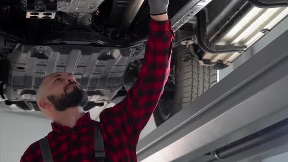 Man Mechanic Repairing a Car in Car Repair Shop. Car Service, Repair and Maintenance alt