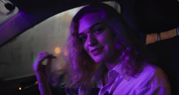 Sexy Woman Touching Hair Flirting Sitting in a Car at Night