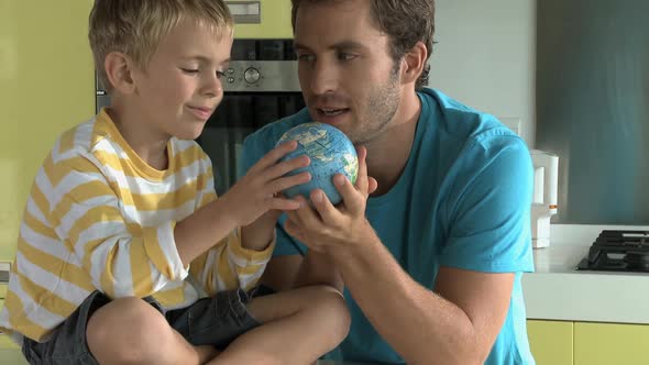 MS OF A FATHER AND SON LOOKING AT A GLOBE