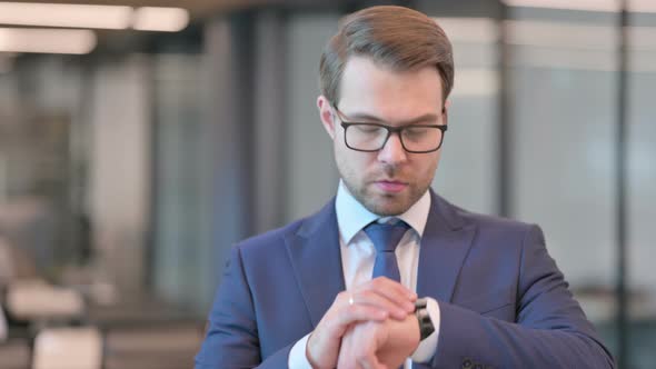 Portrait of Businessman Waiting, Checking Time