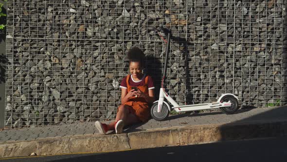 Mixed race woman sitting on sidewalk