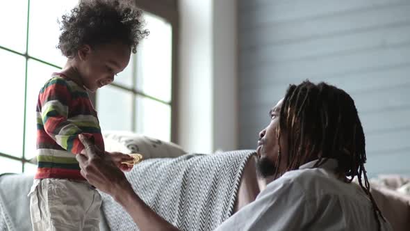 African American Father Helping Son To Come Down