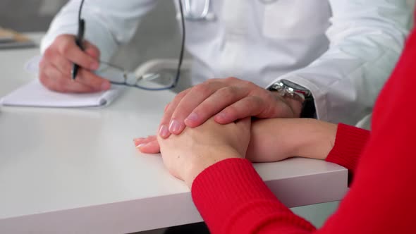 Close up doctor support woman after hearing diagnosis puts hand on patient hands