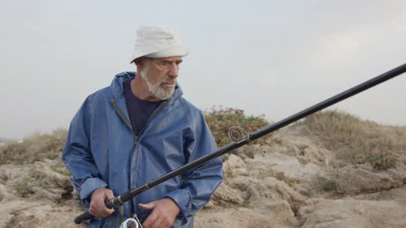 Old fisherman looking into the ocean using his binoculars