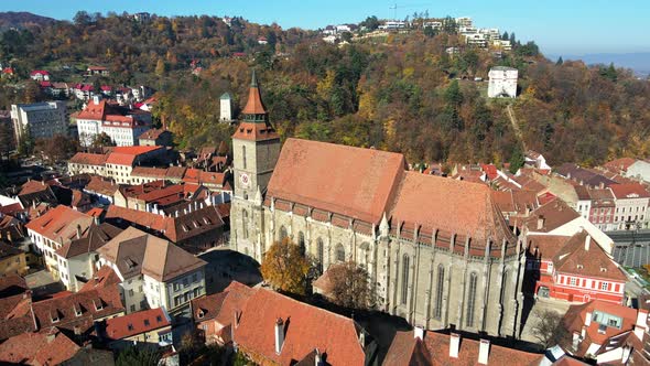 Aerial drone view of The Black Church in Brasov, Romania. Old city centre with buildings and people