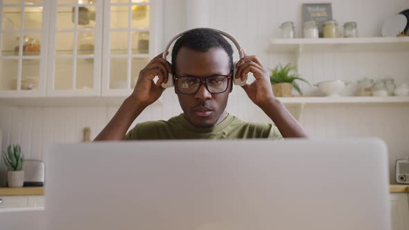 Black Man Student Puts on Headphones to Listen Audio Courses